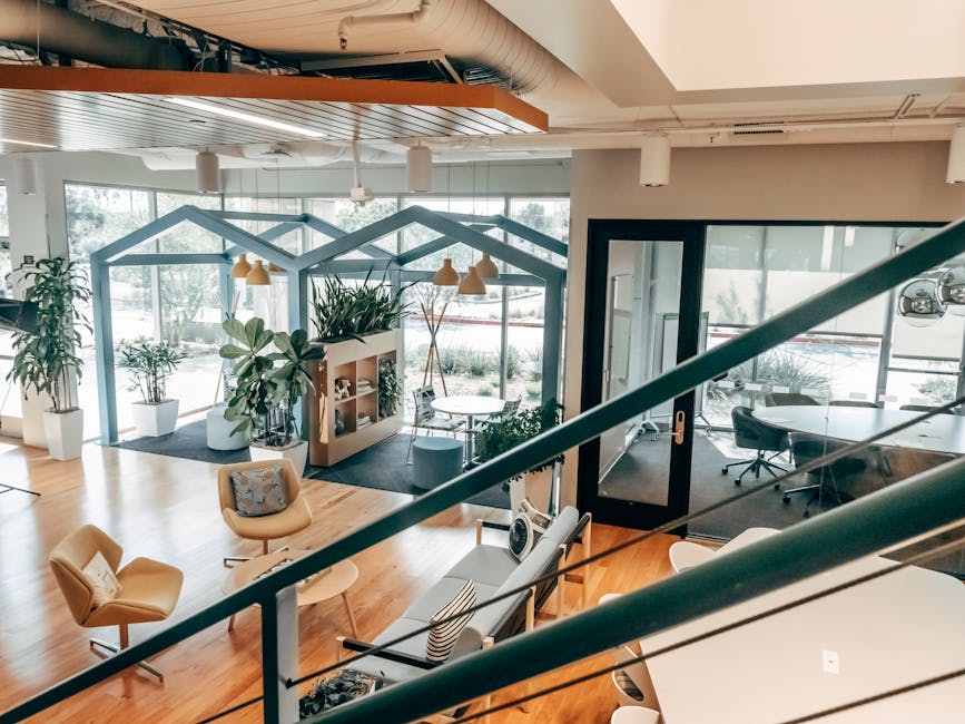 Explore a stylish open office design featuring modern furnishings, green plants, and ample natural light.