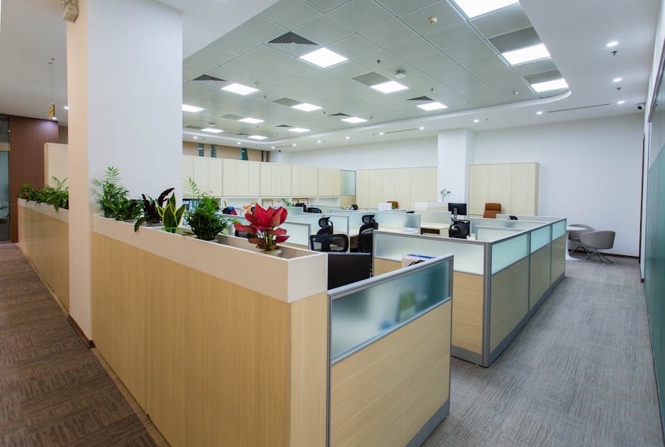 Spacious and bright open office area with cubicles, plants, and contemporary design